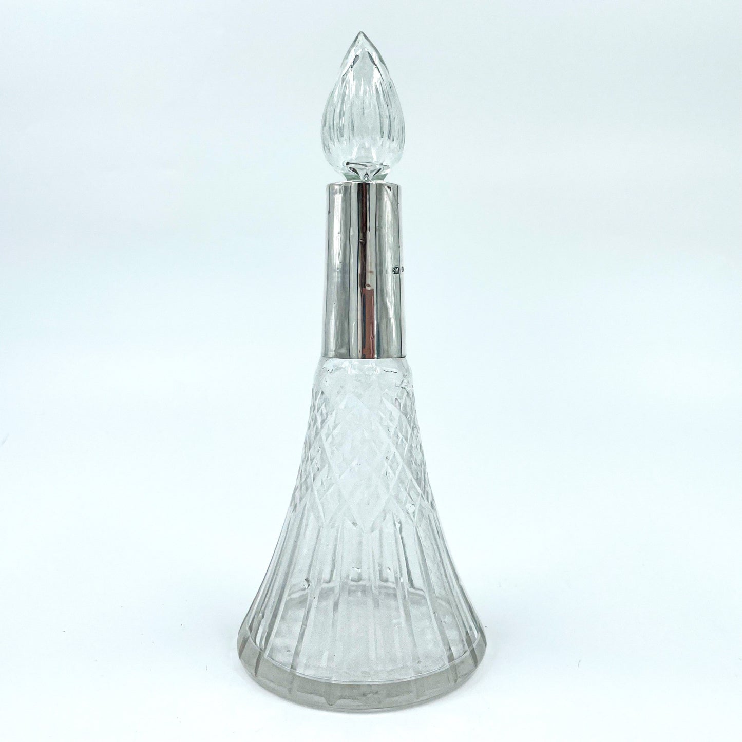 This delicate Edwardian-era perfume bottle is a graceful blend of craftsmanship and history. Featuring a flared cut crystal body with a fluted stopper.