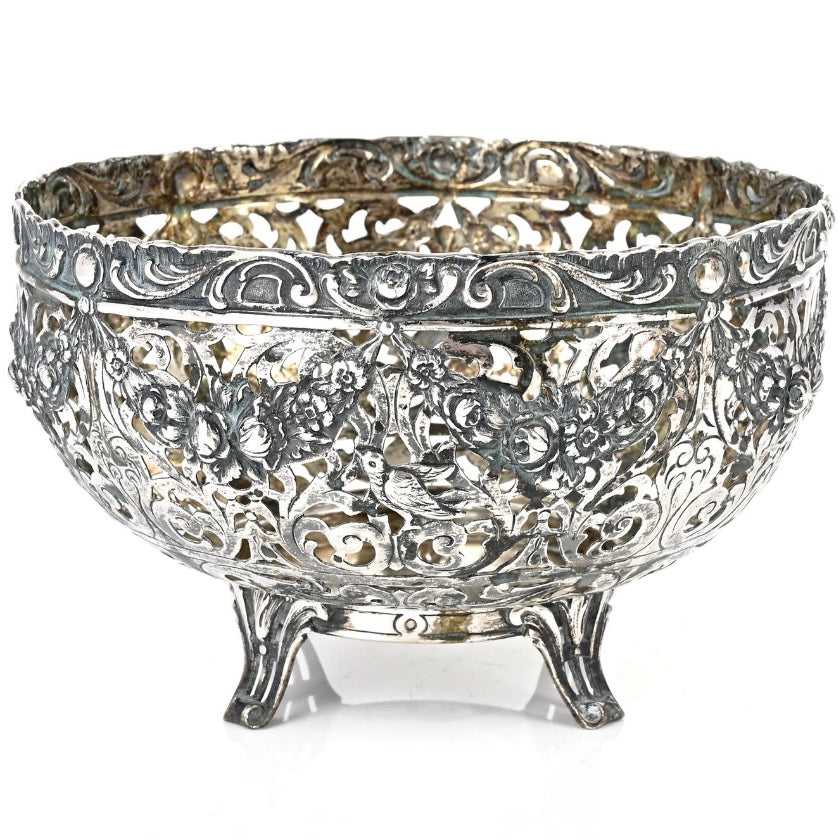 Decorative silver bowl with intricate patterns on a white background