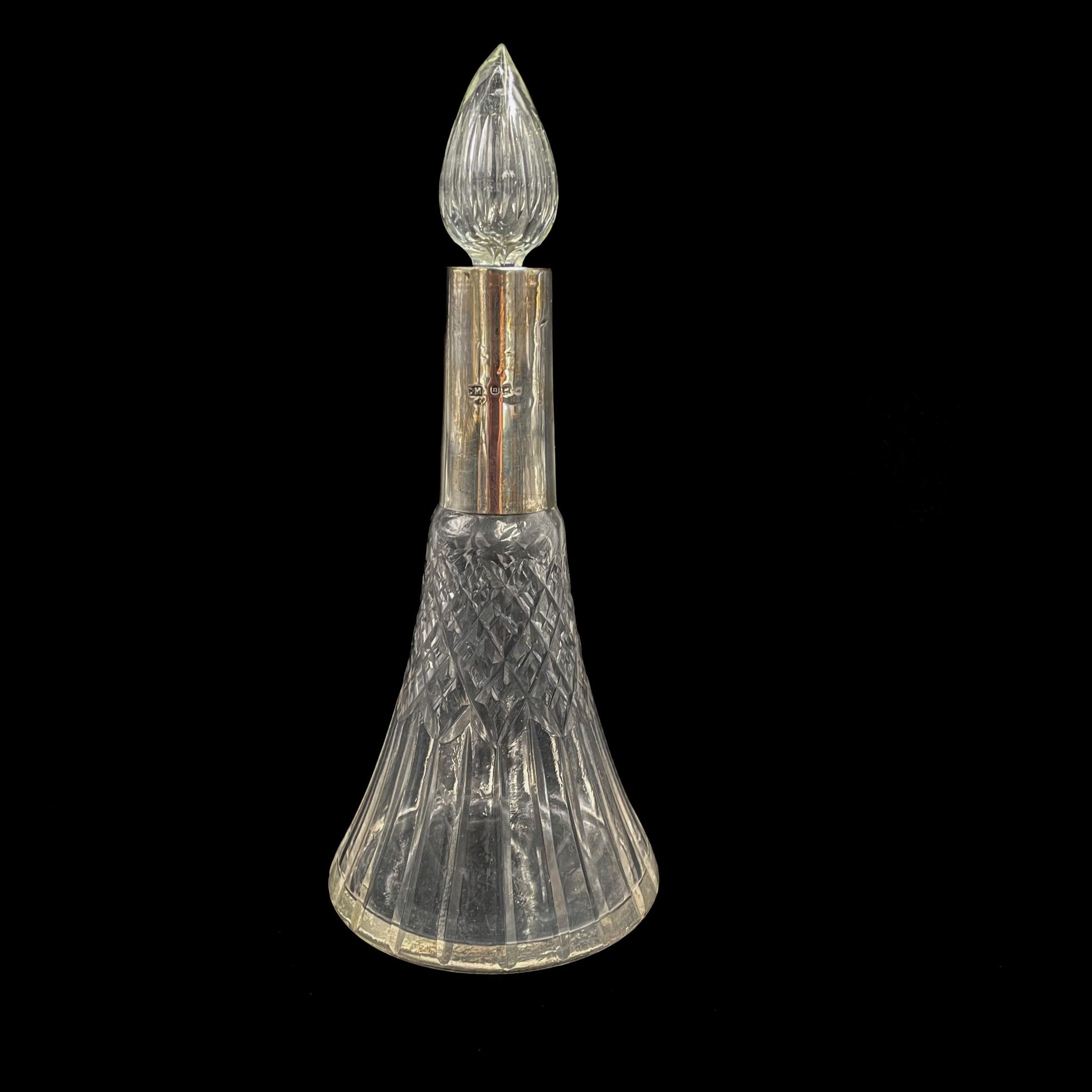 Decorative antique perfume bottle with a sterling silver cap on a black background