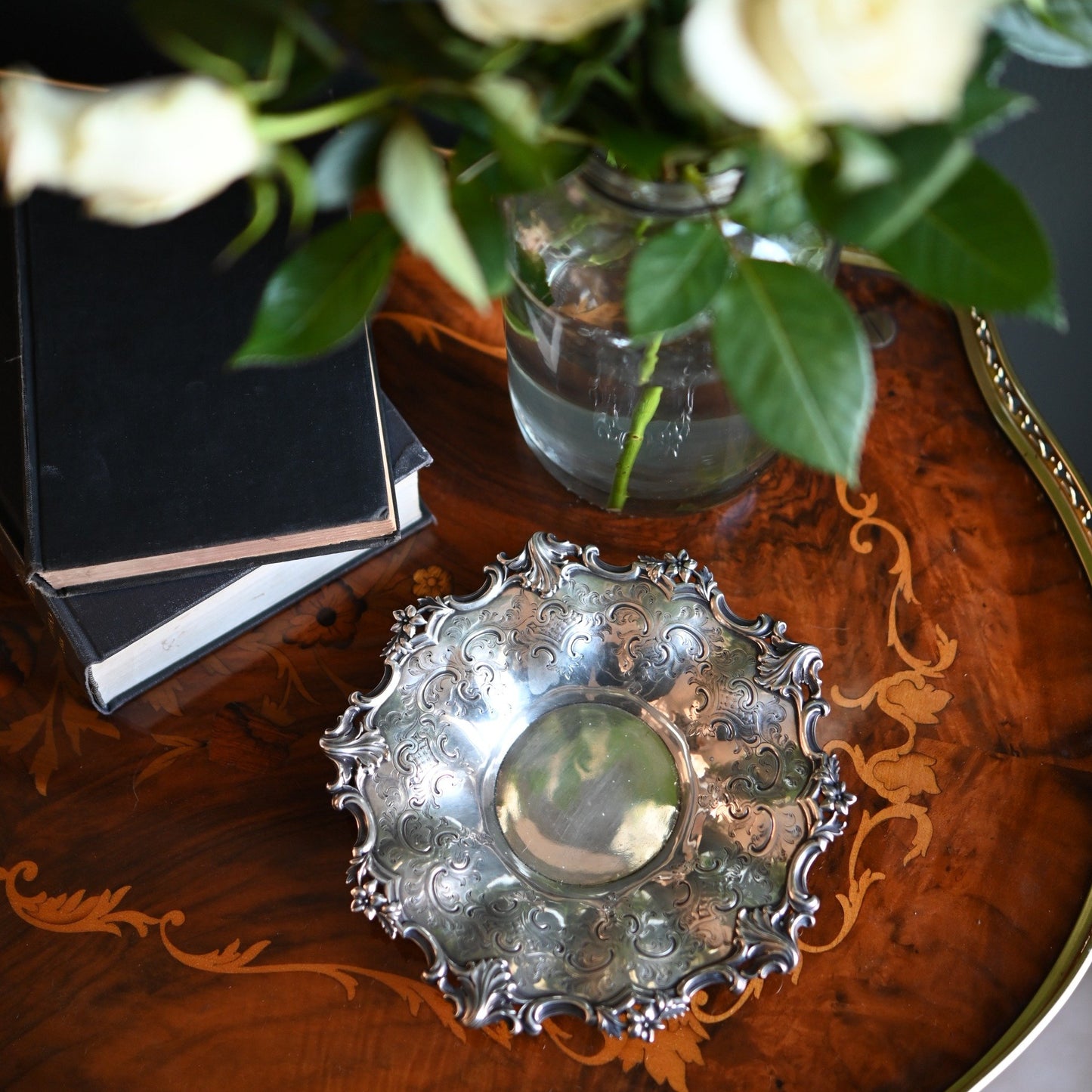 This antique Victorian silver dish is adorned with C-scrolls, acanthus flourishes, and floral motifs.