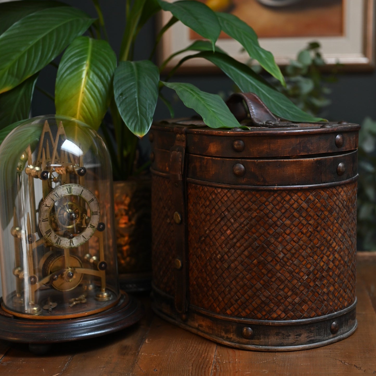 This antique storage box blends warm wood, woven lattice detail, and aged leatherette straps for a richly textured, timeworn look