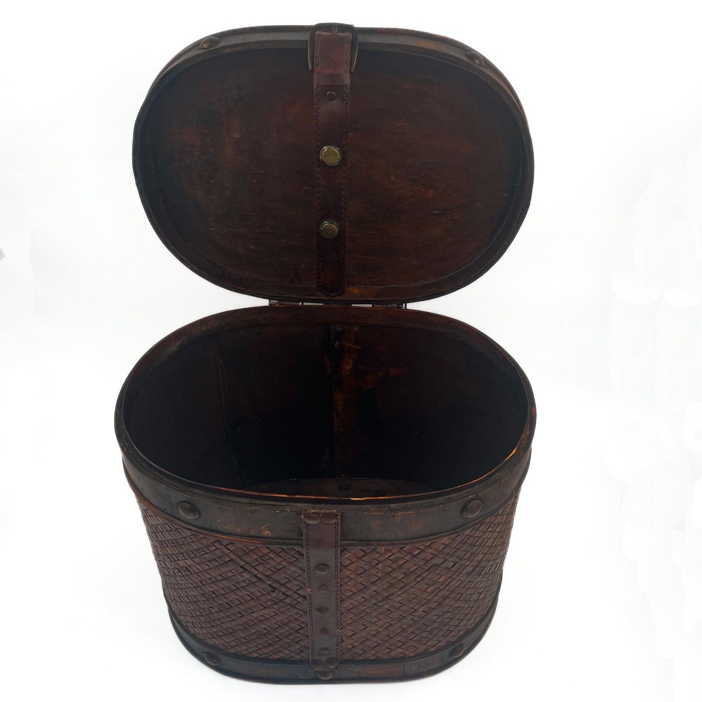 This antique storage box blends warm wood, woven lattice detail, and aged leatherette straps for a richly textured, timeworn look.