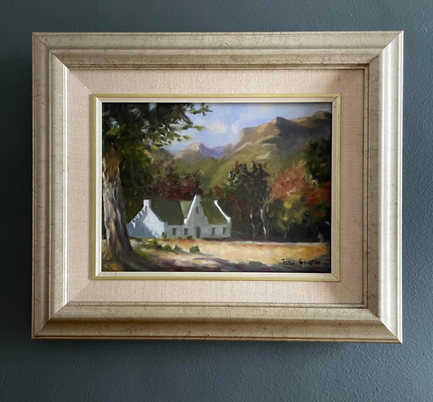 Bathed in soft morning light, this oil painting captures the quiet elegance of a Cape Dutch homestead nestled beneath towering oaks and distant mountain slopes