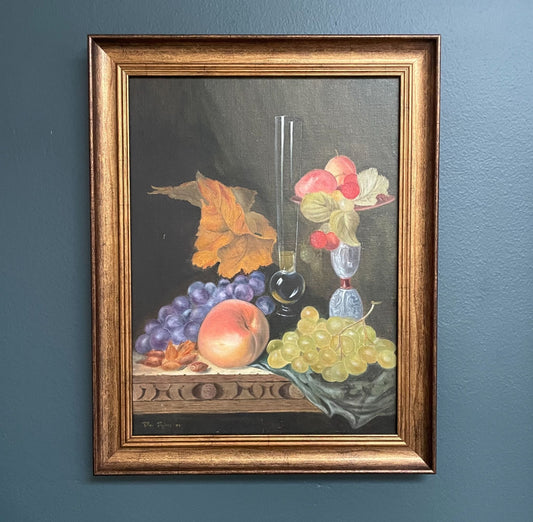 The detailed wood-carved table edge overflowing with ripe grapes, a sun-kissed peach, jewel-toned glassware and autumnal leaves add depth and texture, echoing the timeless tradition of 17th-century Italian still life painting.