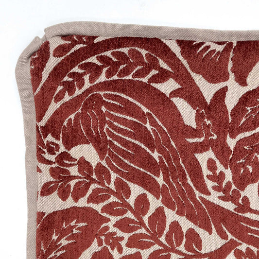 Close-up of a fabric with red bird and leaf pattern on beige background