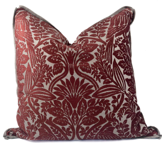Decorative pillow with red floral pattern on a white background