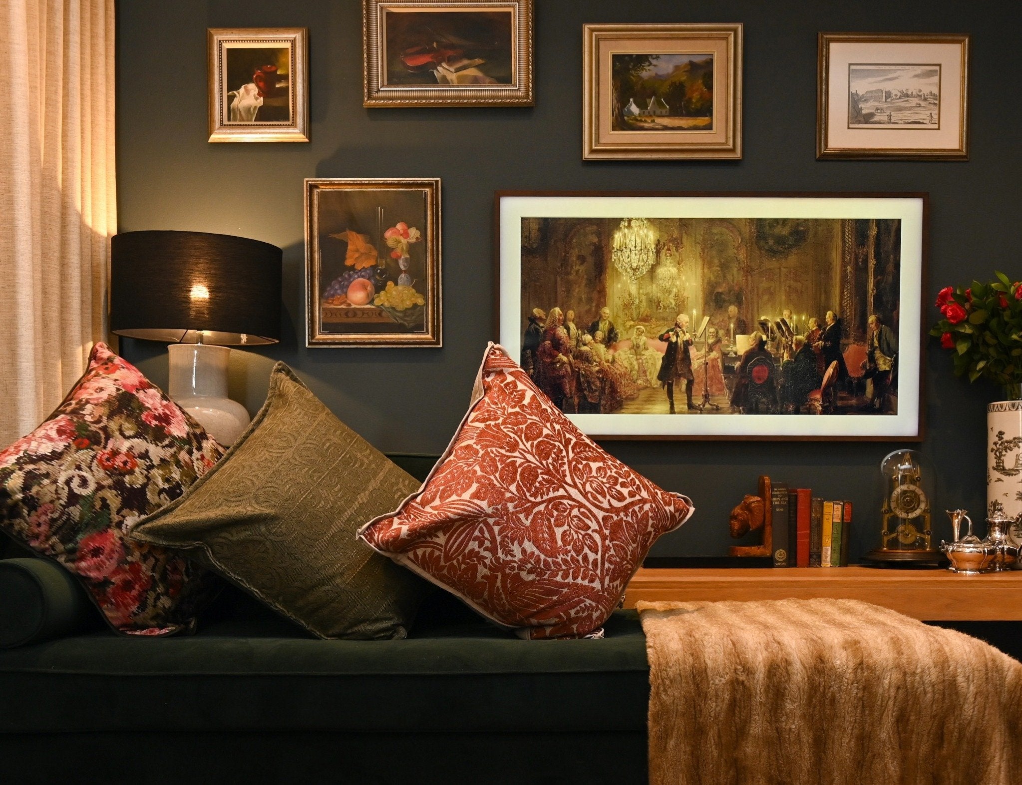 Living room with dark walls, decorative pillows, and framed artwork.