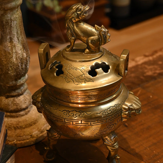 This solid brass Chinese incense burner, topped with a foo dog symbolizes protection and guardian spirit energy.  Cira 1950's.
