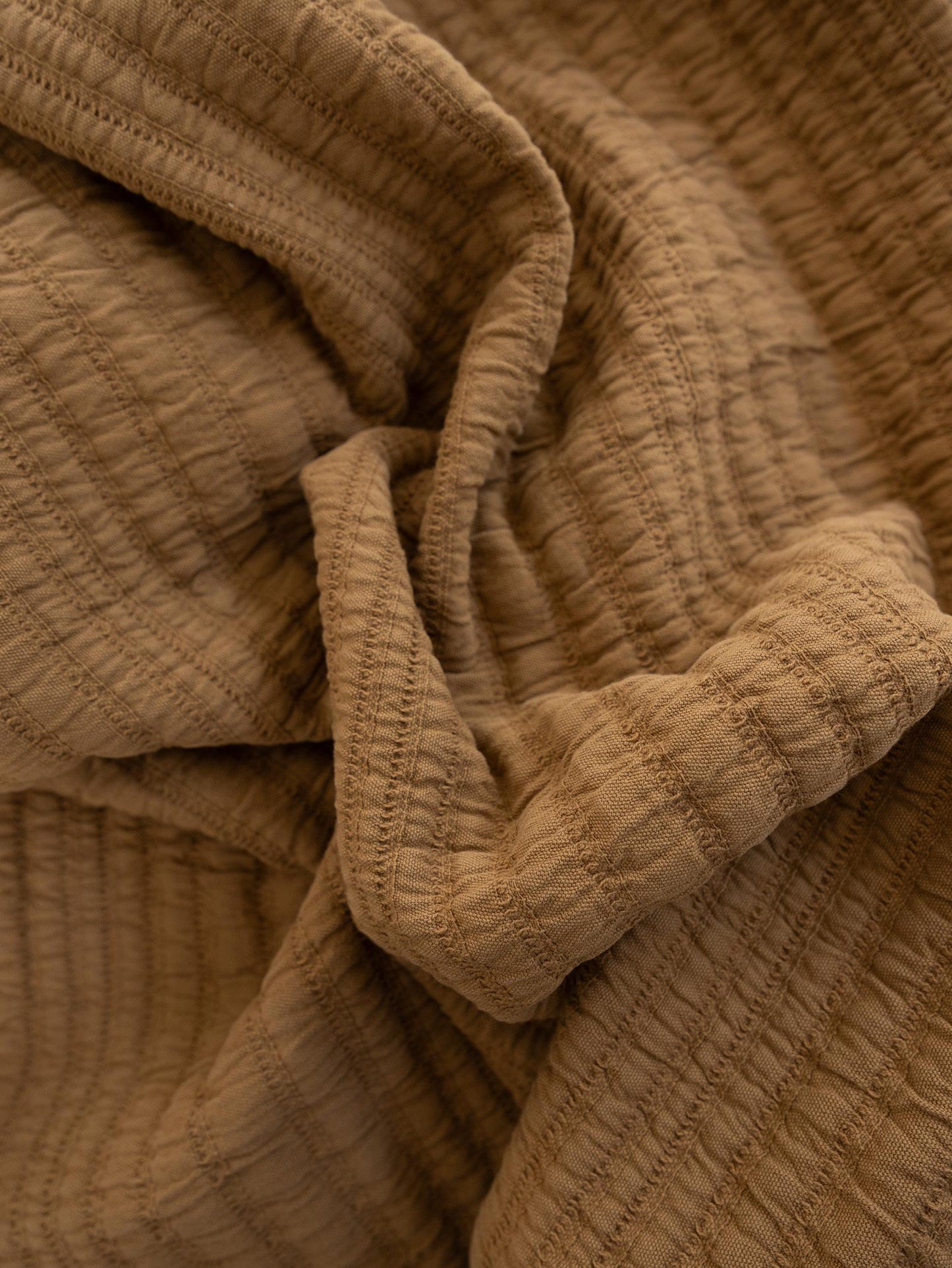 Close-up of textured nutmeg coloured throw blanket