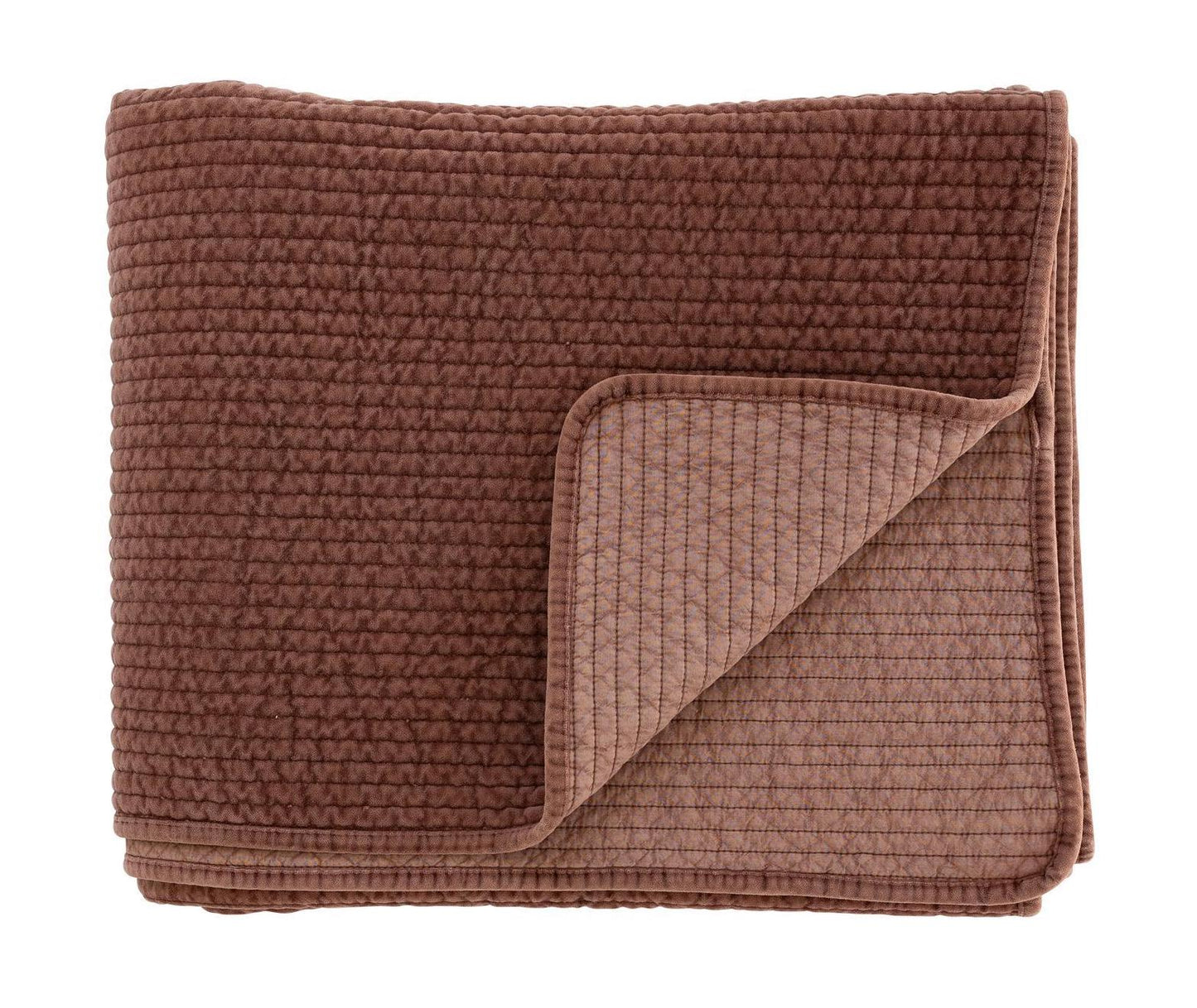 Folded rust coloured textured quilt on a white background