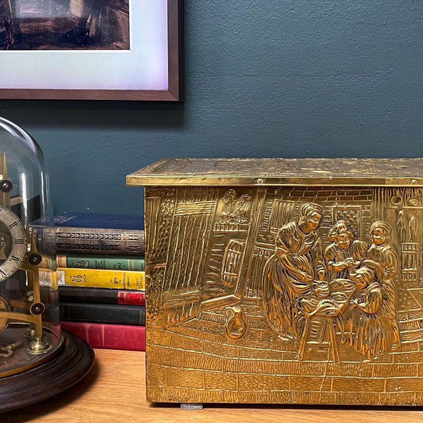 An embossed brass box from the late 19th century, crafted using repoussé techniques, depict a scenes of historical domestic life evoking a sense of nostalgia and tradition.