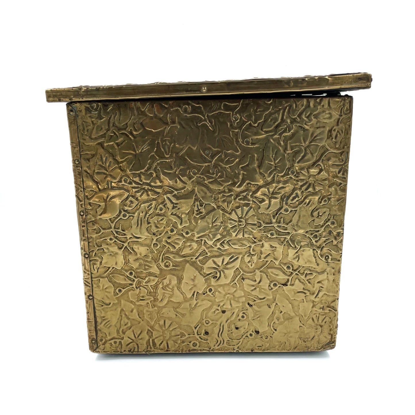 Side view of an embossed brass box from the late 19th century, crafted using repoussé techniques, depict a scenes of historical domestic life.