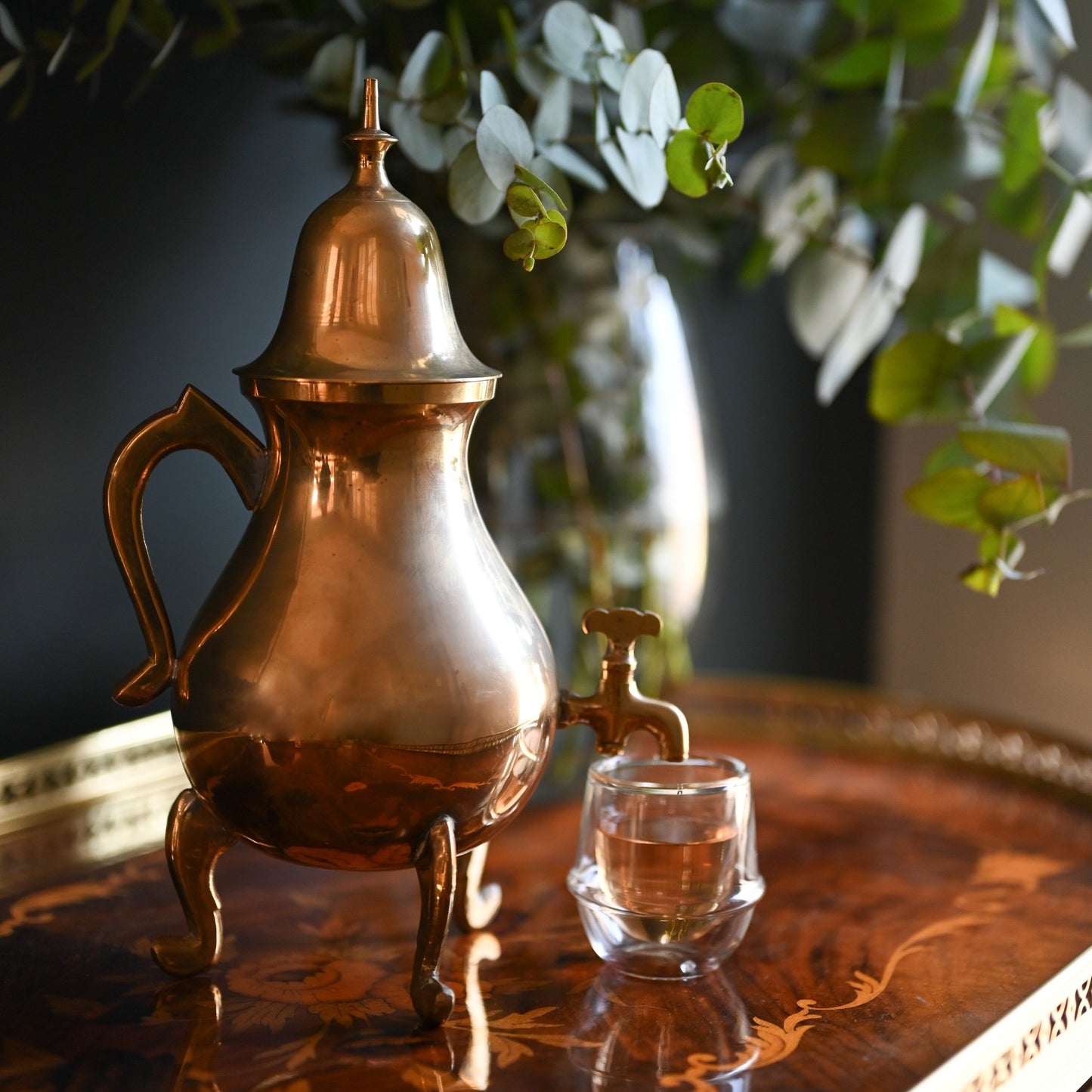 A vintage brass Samovar beautifully displayed on an antique table
