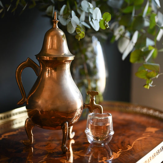 A vintage brass Samovar beautifully displayed on an antique table