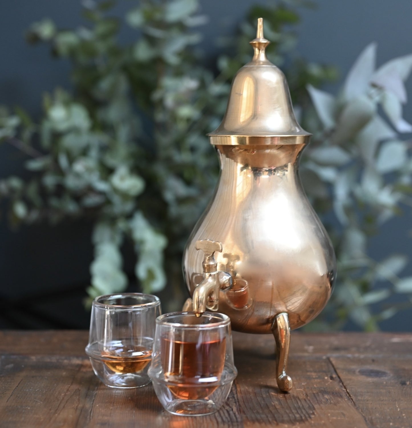 A vintage brass Samovar beautifully displayed on an antique table