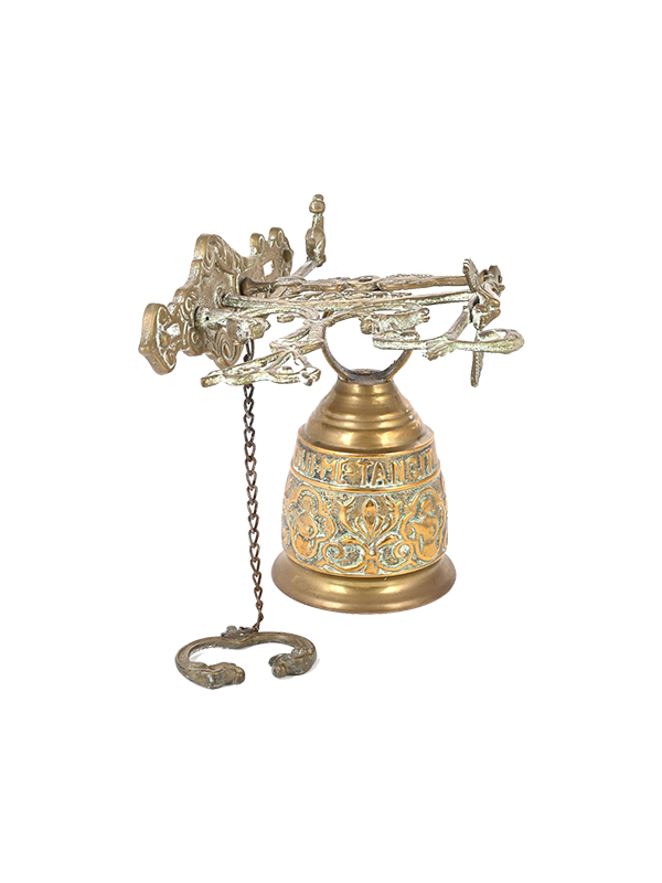 Decorative antique brass bell with intricate designs on a white background
