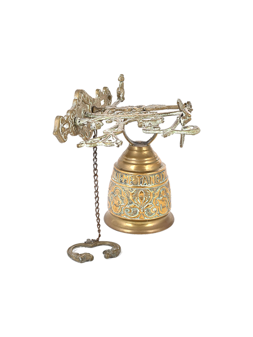 Decorative antique brass bell with intricate designs on a white background