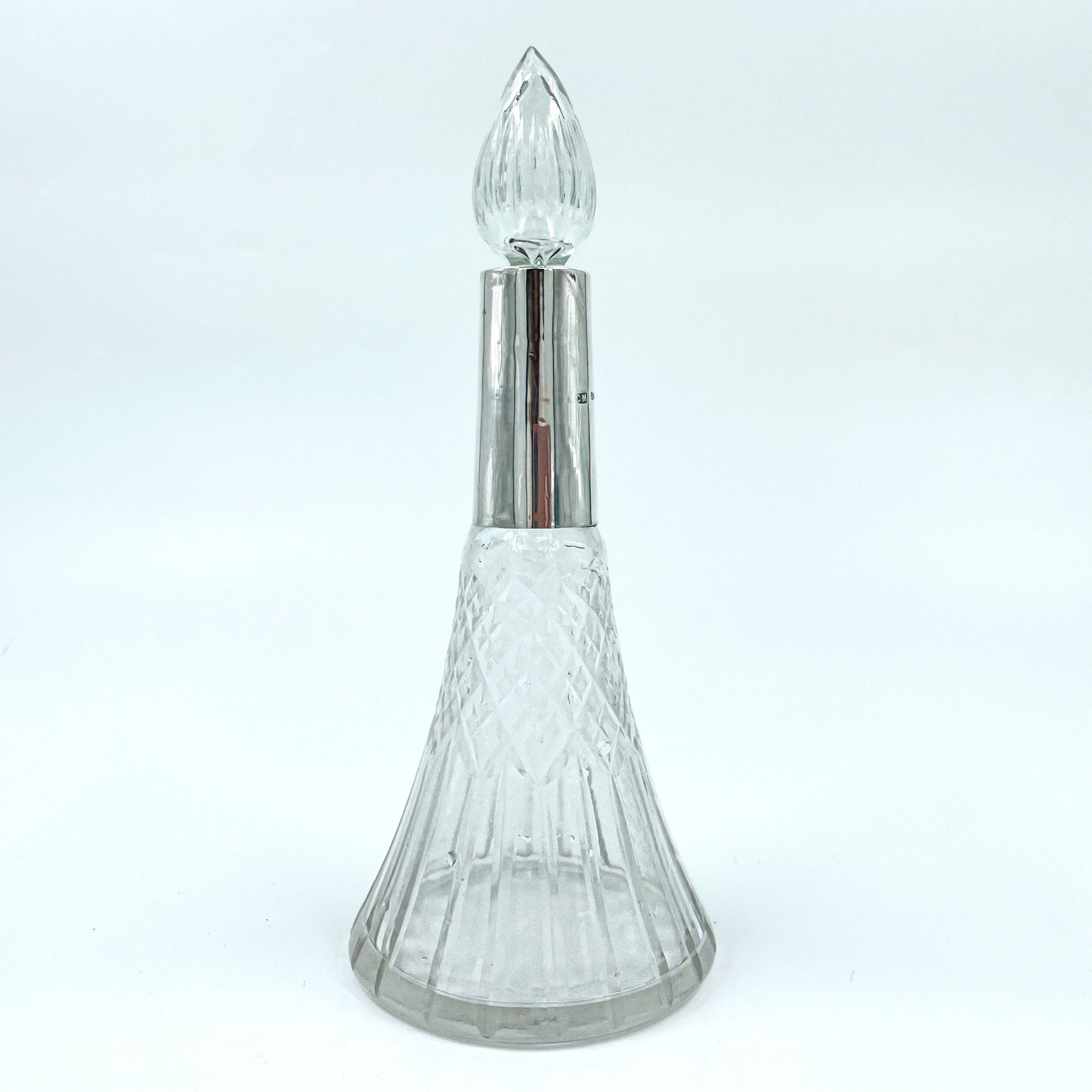 This delicate Edwardian-era perfume bottle is a graceful blend of craftsmanship and history. Featuring a flared cut crystal body with a fluted stopper.