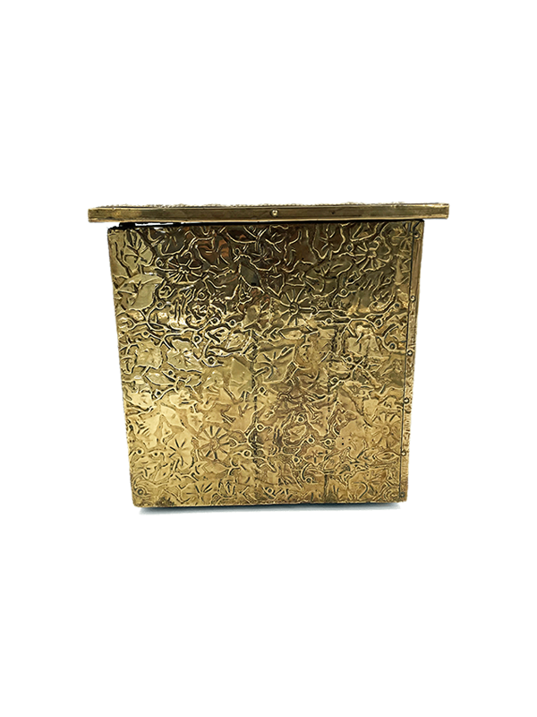 Antique decorative brass storage or firewood box with intricate patterns on a white background