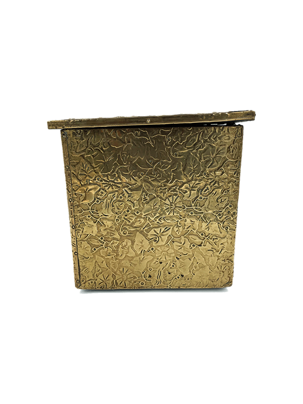 Antique decorative brass storage or firewood box with intricate patterns on a white background