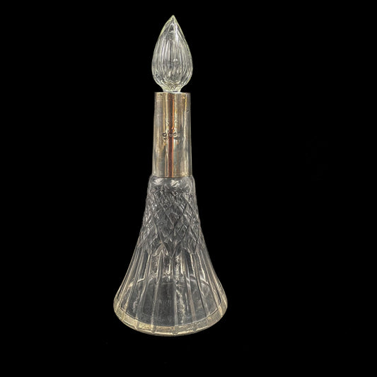 Decorative antique perfume bottle with a sterling silver cap on a black background