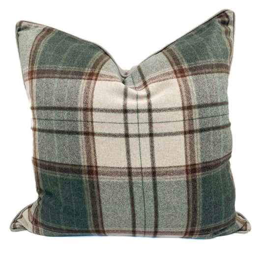 Plaid pillow with green, brown, and white colors on a white background