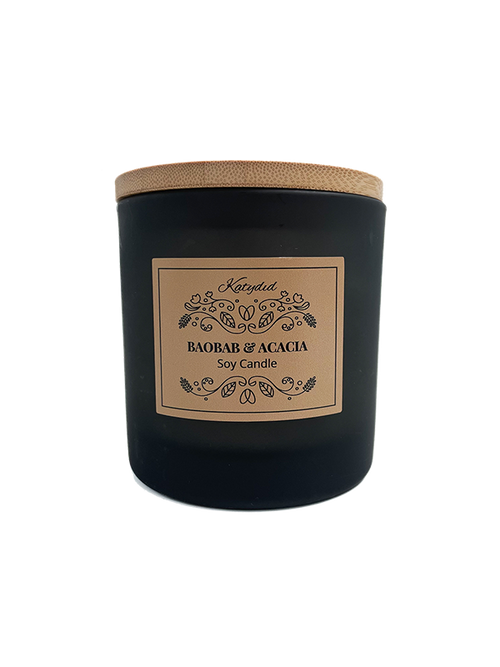 Black candle with a wooden lid and decorative label on a white background