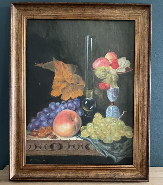 The detailed wood-carved table edge overflowing with ripe grapes, a sun-kissed peach, jewel-toned glassware and autumnal leaves add depth and texture, echoing the timeless tradition of 17th-century Italian still life painting.