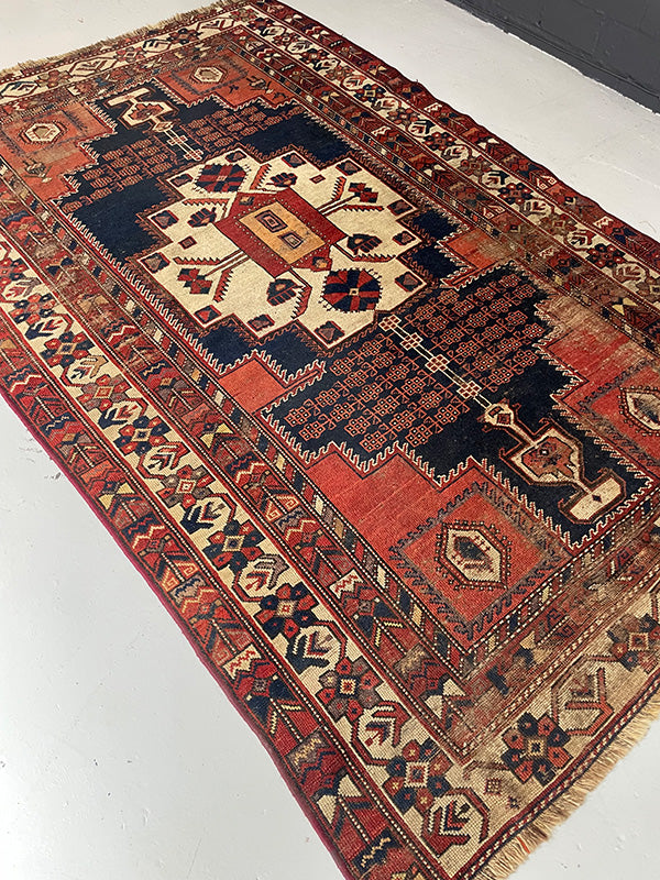 Decorative rug with intricate patterns on a white floor