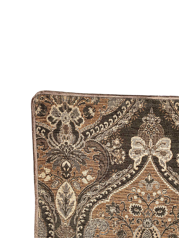 Close-up of a patterned textured fabric of scatter cushion with intricate designs on a white background