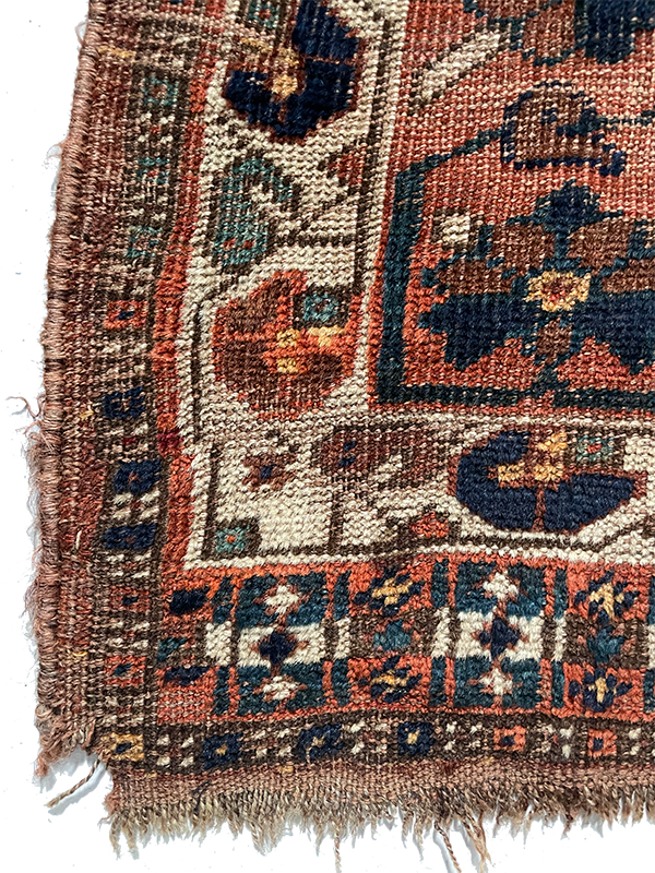 Close-up of a patterned rug with intricate designs on a white background