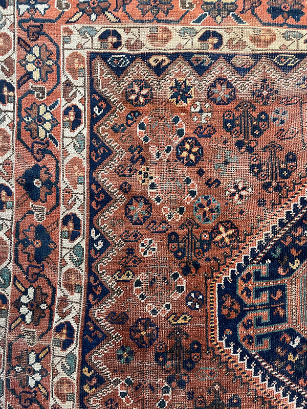 Close-up of a patterned rug with intricate designs in brown, blue, and beige.