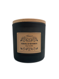 Black candle with a wooden lid and decorative label on a white background