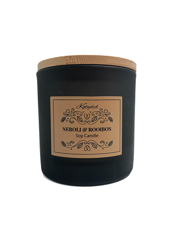 Black candle with a wooden lid and decorative label on a white background
