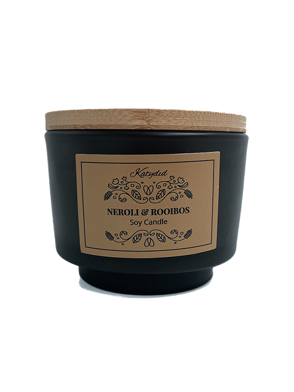 Black candle with a wooden lid and decorative label on a white background