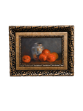 Framed still life painting of oranges ad a silver vase  on a white background