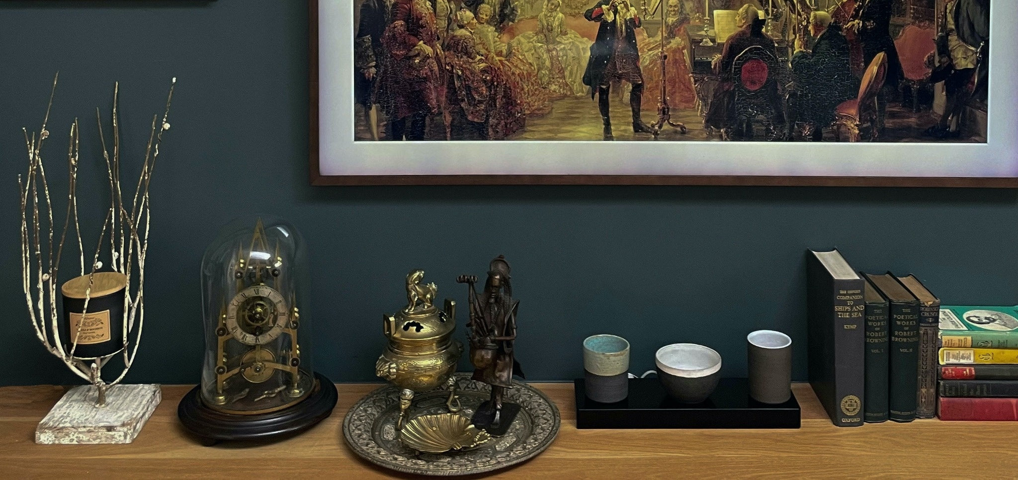 Beautify display of antiques and paintings against a dar wall