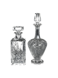 Two vintage crystal decanters on a white background