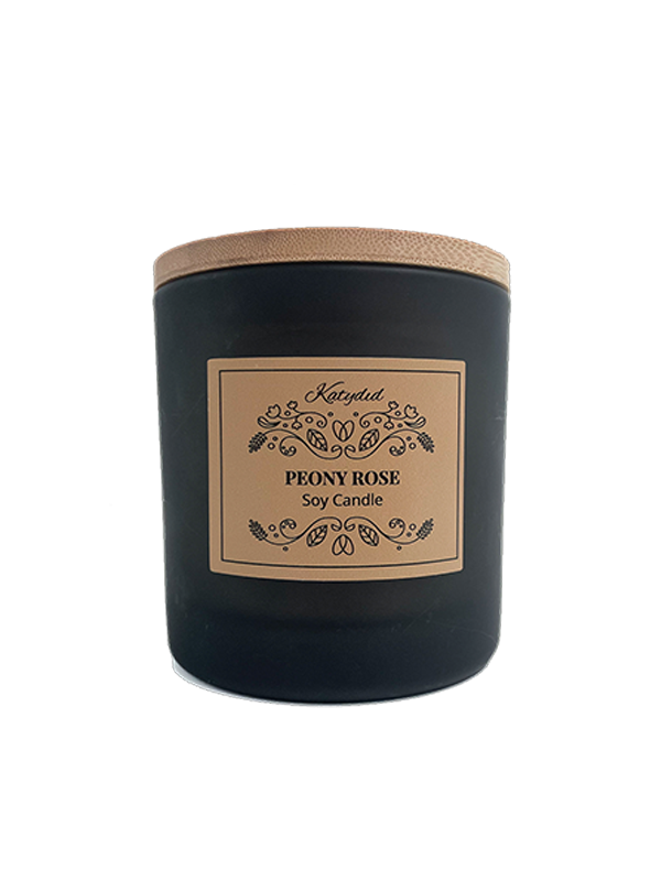 Black candle with a wooden lid and decorative label on a white background