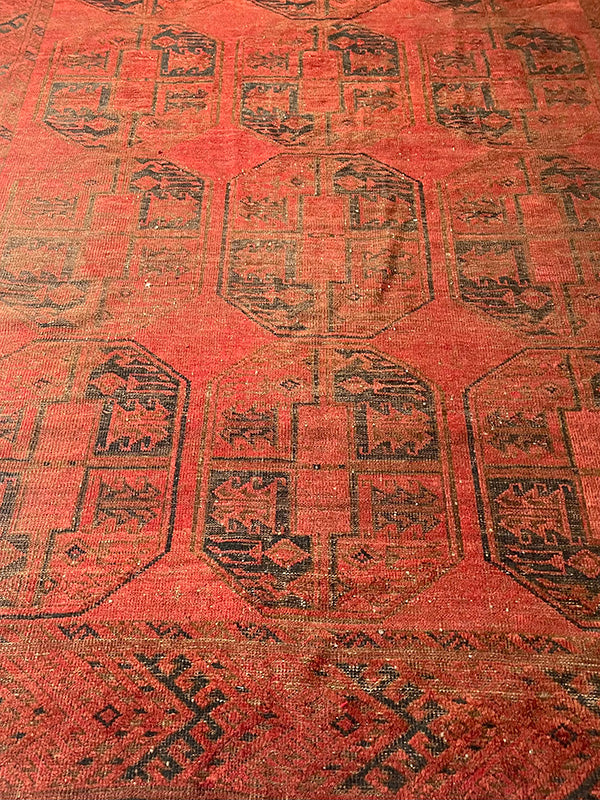 Close-up of a vintage rug with black geometric patterns