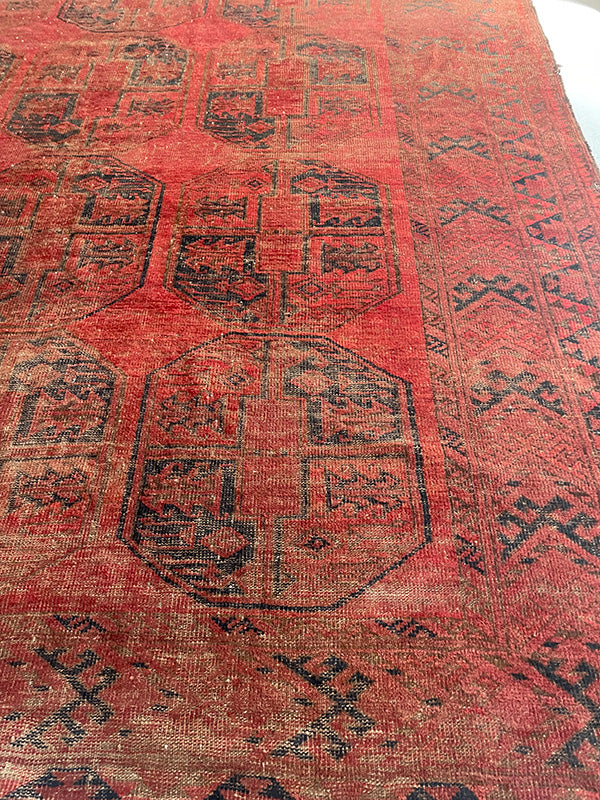 Vintage red rug with black geometric patterns