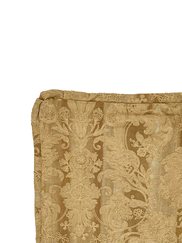 Close-up of a gold embroidery scatter cushion fabric on a white background