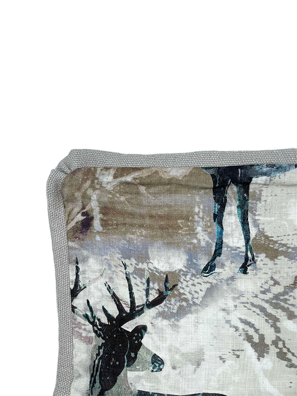 Close up of scatter cushion fabric with deer design on a white background