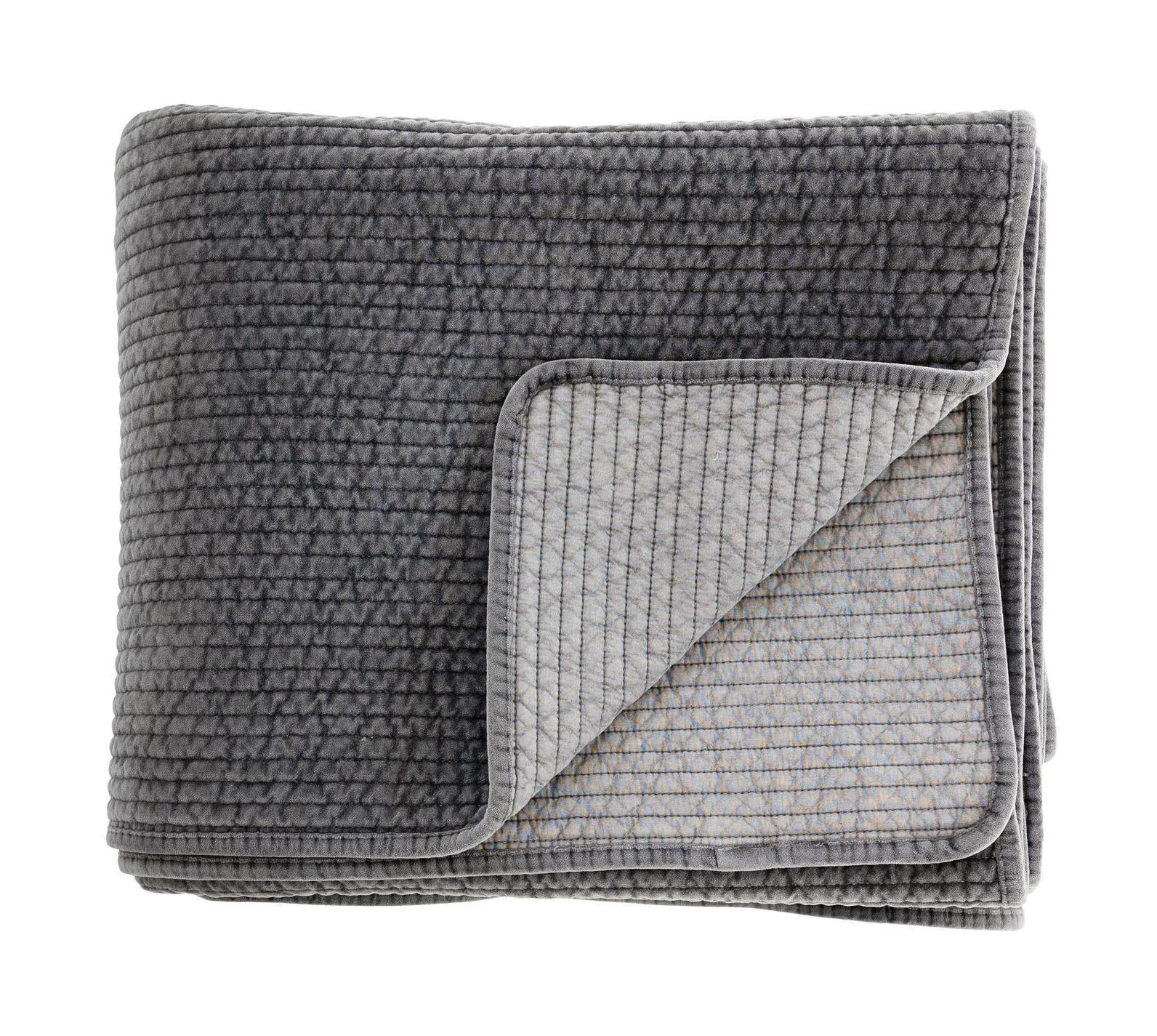 Folded grey textured quilt on a white background