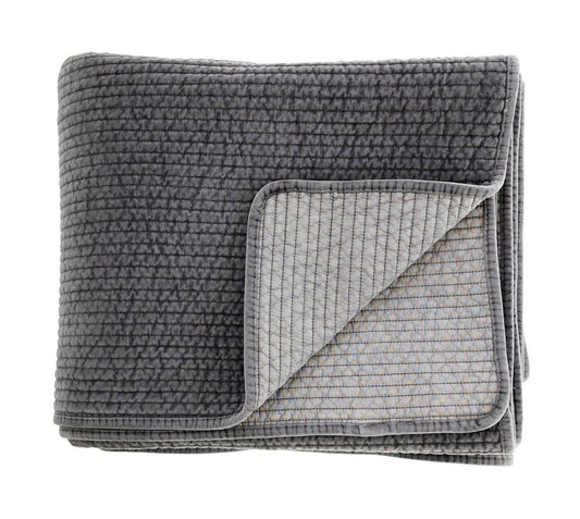 Folded grey textured quilt on a white background