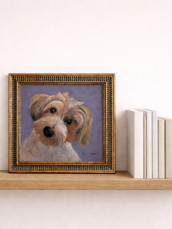 Framed painting of a dog on a shelf with books