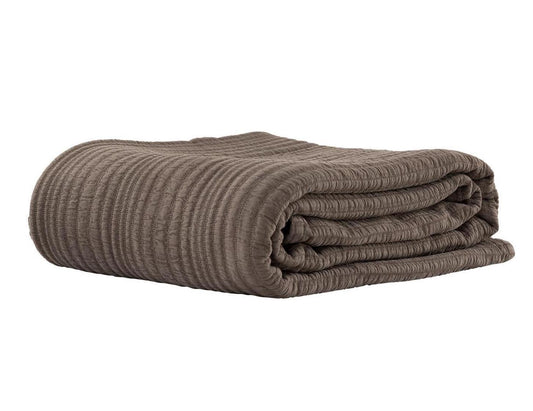 Folded brown textured blanket on a white background