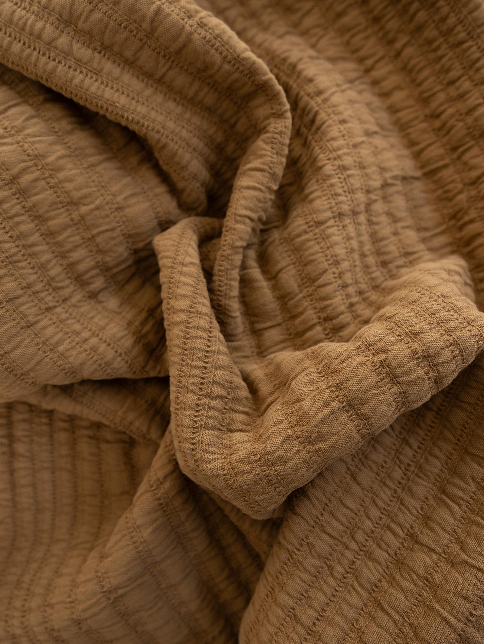 Close-up of textured nutmeg coloured throw blanket