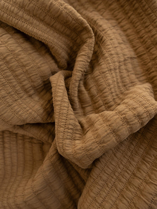 Close-up of textured nutmeg coloured throw blanket