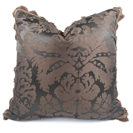 Decorative pillow with intricate pattern and tassels on a white background